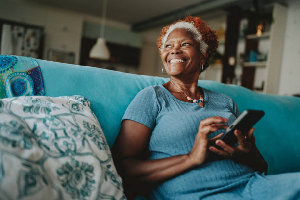 A woman smiling while using her phone at home